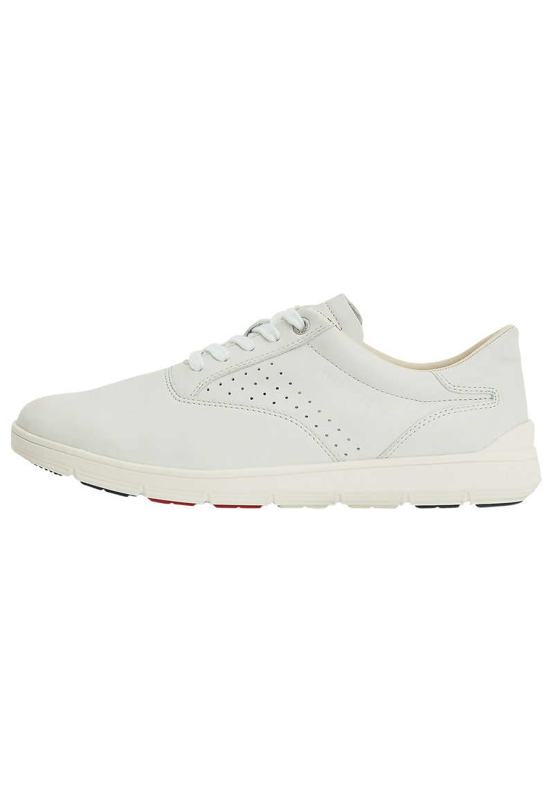 Sneaker in pelle bianca con finitura liscia, caratterizzata da dettagli perforati, lacci piatti e una suola leggera con accenti rossi e neri.