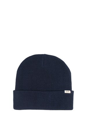 Beanie in maglia blu scuro con orlo piegato e una piccola etichetta in tessuto ricamata. Tessuto liscio e design classico e aderente.