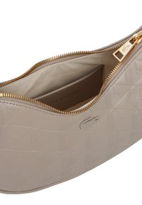 Borsa a mano light beige con motivo geometrico a rilievo, cerniera dorata parzialmente aperta e fodera interna in tessuto con tasca.