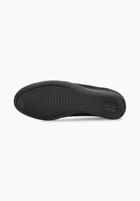 Semelle de chaussure de sport noire avec une surface en caoutchouc texturé, présentant un motif de crampons et un logo de marque au talon pour une meilleure adhérence et durabilité.