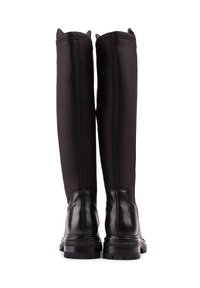 Black knee-high riding boots with a smooth leather lower section, stretchy fabric upper, and a sturdy rubber sole. No visible hardware or embellishments.