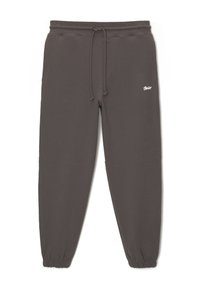 Pantalon de jogging gris foncé avec taille et poignets élastiques, cordon de serrage ajustable et petit logo blanc sur la cuisse droite.