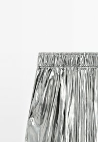 Metalen zilveren rok met een elastische tailleband, gekreukt design en een gladde, glanzende textuur. Geen zichtbare hardware.