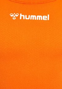 Helle orange Textilie mit einer strukturierten Oberfläche; zeigt ein weißes "hummel"-Logo, das prominent oben angezeigt wird.