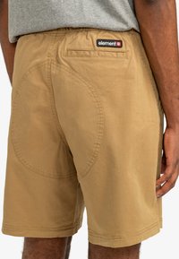 Khaki shorts with an elastic waistband, back pocket, and circular stitching detail on the side. Made from lightweight fabric.