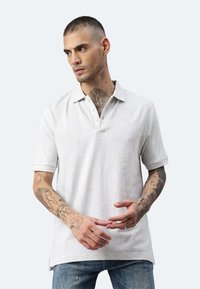 Hellgraues Polohemd mit Kragen, kurzen Ärmeln, einer Dreiknopf-Leiste, glatter Textur und seitlichen Schlitzdetails.