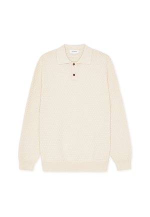 Πλεκτό πόλο πουλόβερ σε κρεμ απόχρωση με υφή, μακριά μανίκια και πατιλέτα με τρία κουμπιά. Απαλό ύφασμα με ριμπ τελείωμα.