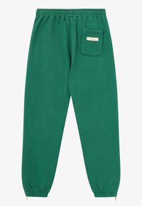 Pantalons de survêtement verts en mélange de coton, avec une taille élastique, des poignets fuselés et une poche arrière unique avec une petite étiquette.