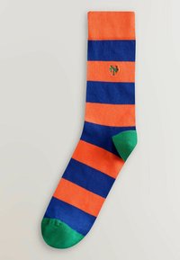 Chaussette avec larges rayures horizontales orange et bleu marine, bout et talon verts, et petit logo "NY" vert brodé près du haut.