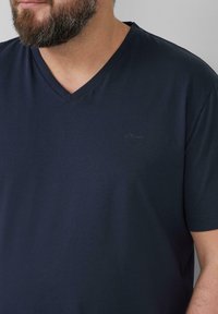Navyblauw V-hals T-shirt gemaakt van zacht, soepel materiaal. Voorzien van een subtiele s.Oliver-logo op de borst, met korte mouwen en een relaxte pasvorm.