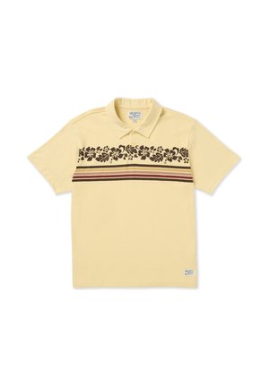 Polo de algodón amarillo claro con un patrón floral en marrón oscuro y franjas granate cerca del pecho. Cuenta con cuello y mangas cortas.