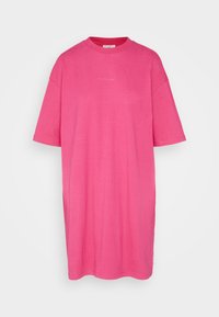 Ylihrö vaaleanpunainen t-paita, joka on valmistettu puuvillasta. Siinä on pyöreä pääntie, lyhyet hihat ja suora helma. Yksinkertainen muotoilu ilman näkyviä kuvioita.