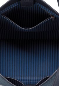 Navy blue handbag interior with black and blue vertical striped lining and a zippered pocket inside.