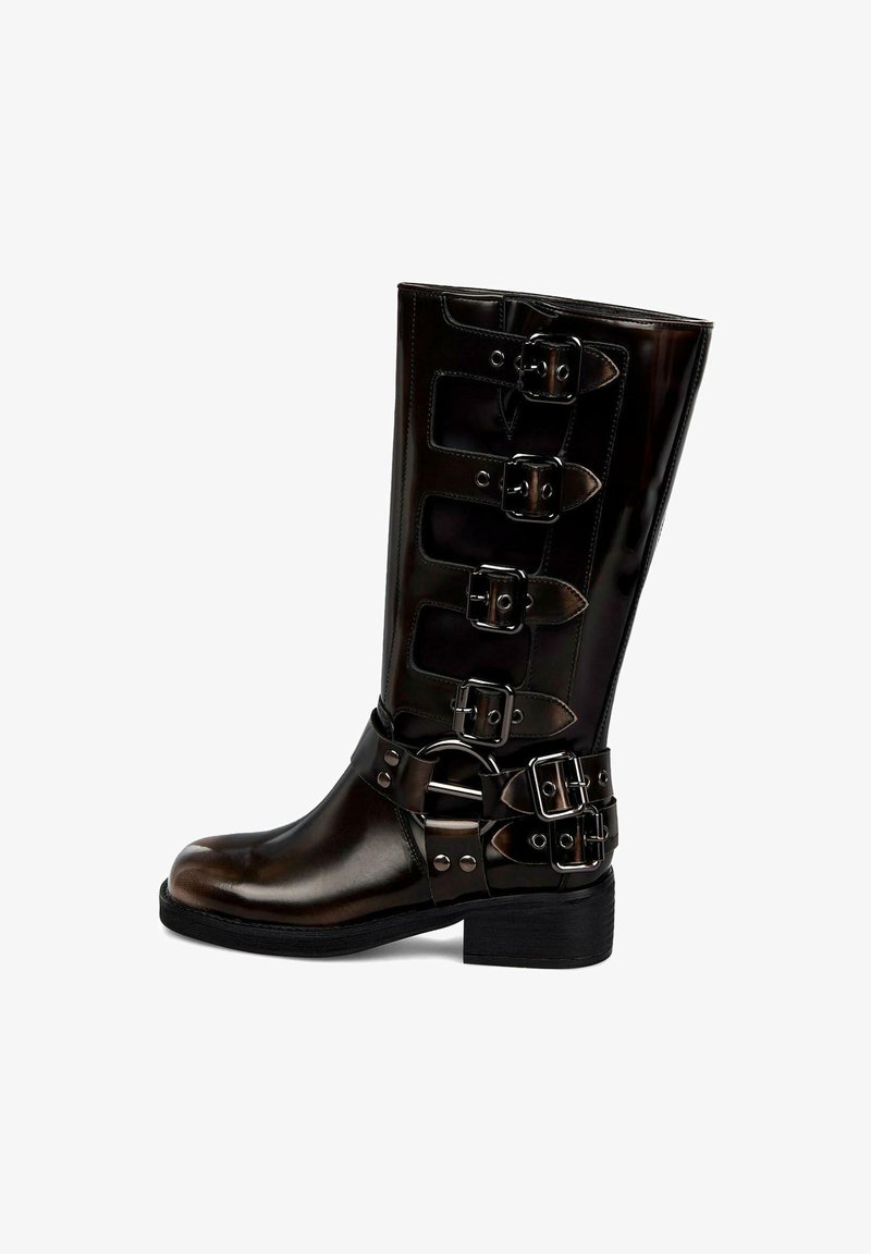 Botte noire brillante mi-mollet avec cinq bandes à boucles et un petit talon sur fond blanc.