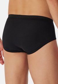 Svarta bomullsboxershorts med mjukt elastiskt midjeband, med en slät textur och en åtsittande passform som framhäver bärarens fysik.