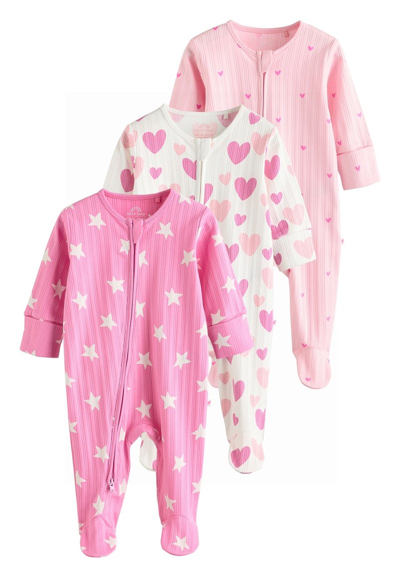 Trois grenouillères pour bébé : une rose avec des étoiles blanches, une blanche avec des cœurs roses, et une rose clair unie. Toutes ont une texture côtelée et des fermetures éclair.