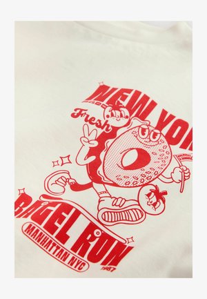 Bijela majica s crvenim grafičkim otiskom likova krafne i rajčice, uz tekst "NEW YORK BAGEL RUN" i "Svježe."