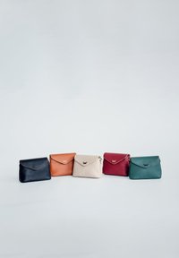 Fünf Schultertaschen aus navy, orange, beige, bordeaux und teal Leder, mit einem Klappenverschluss und dezenten goldenen Hardware-Details.