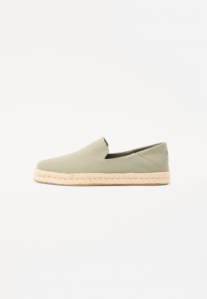 Chaussure slip-on en toile verte avec un bout arrondi et une semelle en jute tressé. Présente des coutures minimales et une coupe à la cheville pour une meilleure respirabilité.