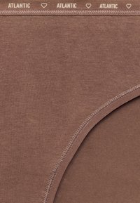 Brązowa bawełniana bielizna o gładkiej fakturze i przeszywanym brzegu. Pas posiada powtarzające się białe napisy „ATLANTIC”.