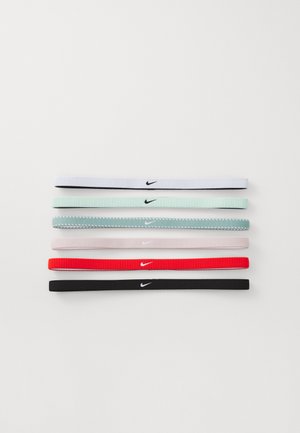 Zes Nike-haarbanden in wit, muntgroen, grijs, rood en zwart, met een zachte, gestructureerde stof en een klein contrasterend logo.