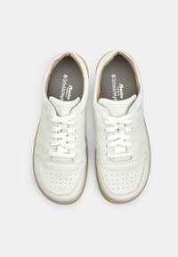 Sneakers bianchi in pelle con profilo basso, punta perforata e suola in gomma beige. Presentano lacci piatti e sottili strisce laterali.