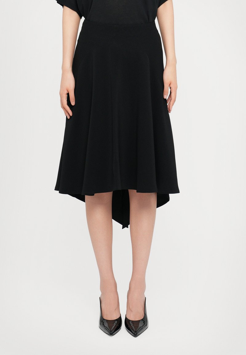 Black flared skirt with a high-low hem, made from a soft fabric. Features a smooth waistband and flows gently from the waist.