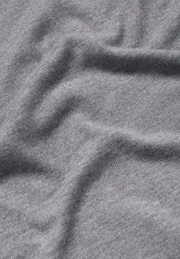 Sivi materijal s glatkom teksturom i finim pletenim uzorkom, s blagim valovima i naborima. Lagano melirani izgled.