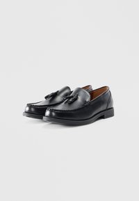 Black leather loafers with decorative stitching and tassel accents. Rounded toe and low block heel, featuring a smooth texture.