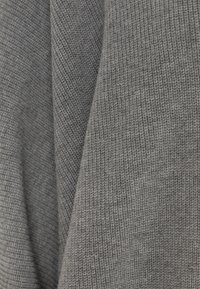 Tessuto di maglia grigia con un motivo a coste testurizzato; morbido e leggero, che mette in mostra diverse texture e una leggera lucentezza.