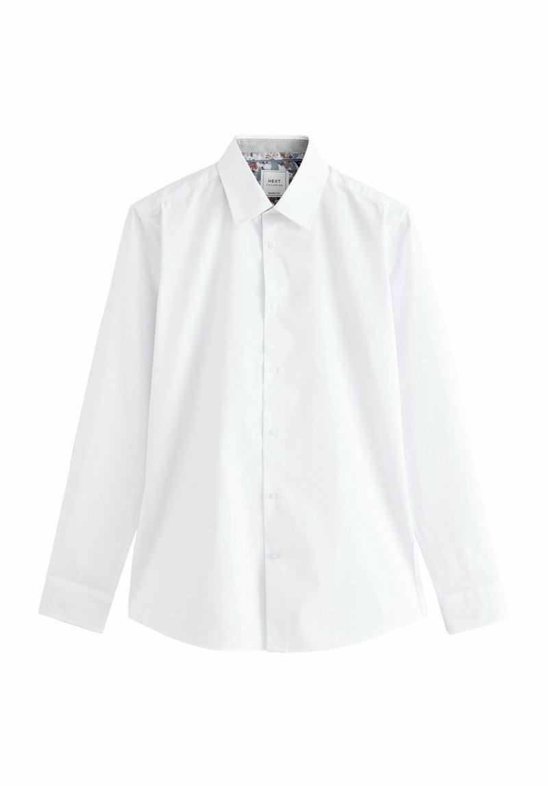 Camisa blanca de manga larga con un cuello clásico, cierre de botones y tejido texturizado. El interior presenta un detalle acentuado con un patrón.