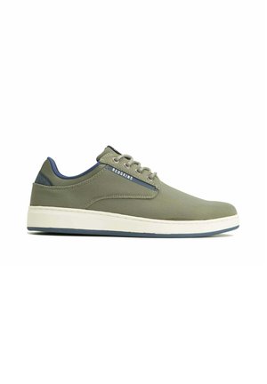 Baskets décontractées vert olive avec semelle blanche, doublure intérieure bleue, lacets et étiquette "REDSKINS" sur le côté.