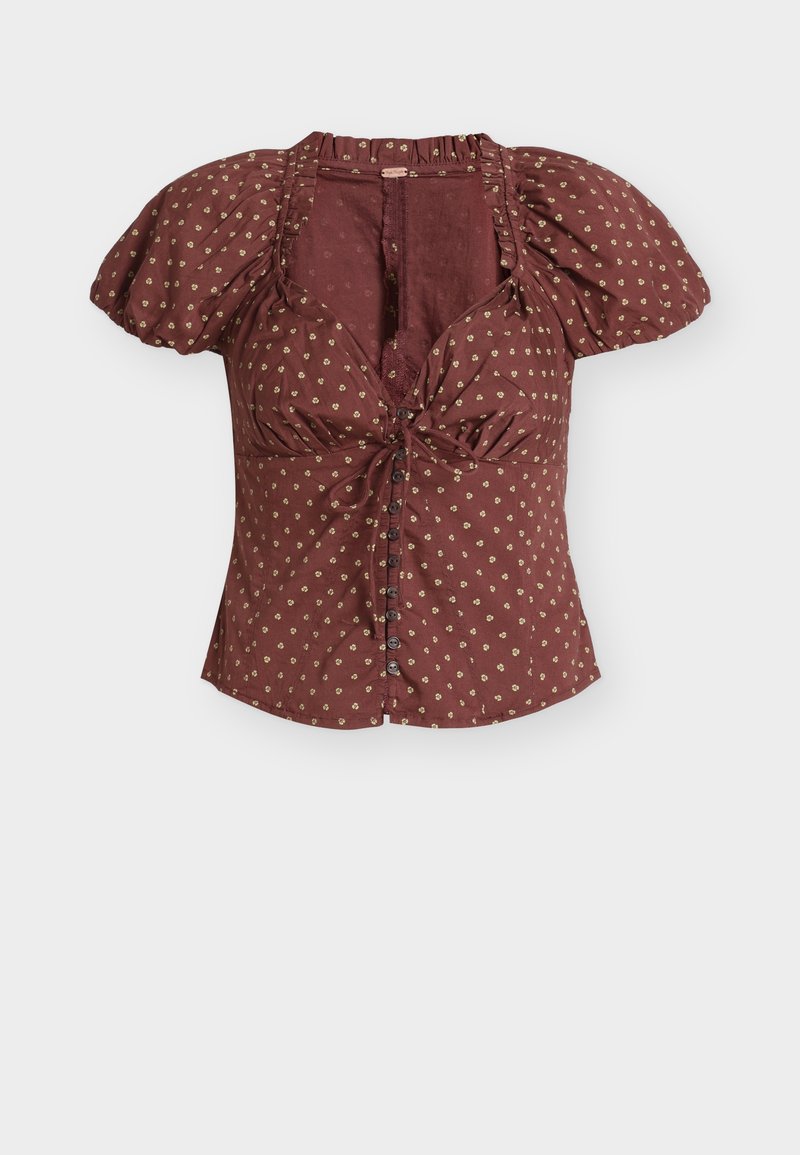 Blusa color granata con maniche a sbuffo e fiocco frontale, con motivi floreali dorati, dettagli con bottoni e tessuto strutturato.