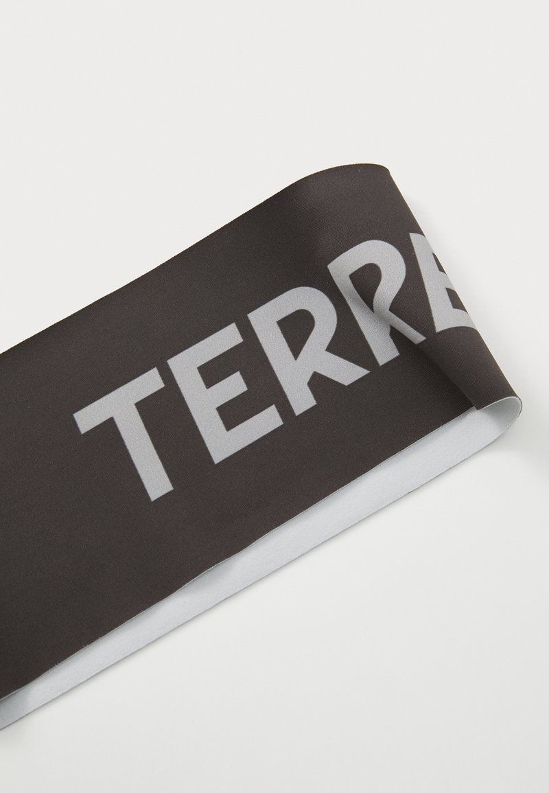 Black fabric headband with light gray text reading "TERRE" along its length, featuring a smooth, stretchy texture and rounded edges.
