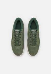 Baskets en daim vert avec fermeture à lacets. Doublure textile douce, détails perforés sur le bout et semelle en caoutchouc blanche contrastante.