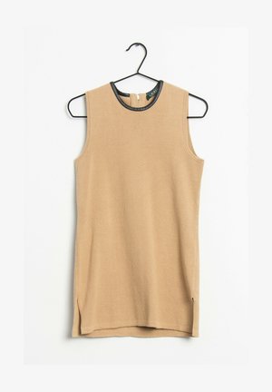 Beige ärmlös stickad topp med en rund svart krage, som har en dragkedja i ryggen och sprund i fållen för ökad rörelsefrihet.