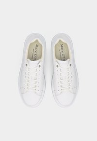 Ζευγάρι λευκών δερμάτινων αθλητικών παπουτσι ών Marc O’Polo με λευκά κορδόνια, φωτογραφημένα από πάνω σε απλό λευκό φόντο.