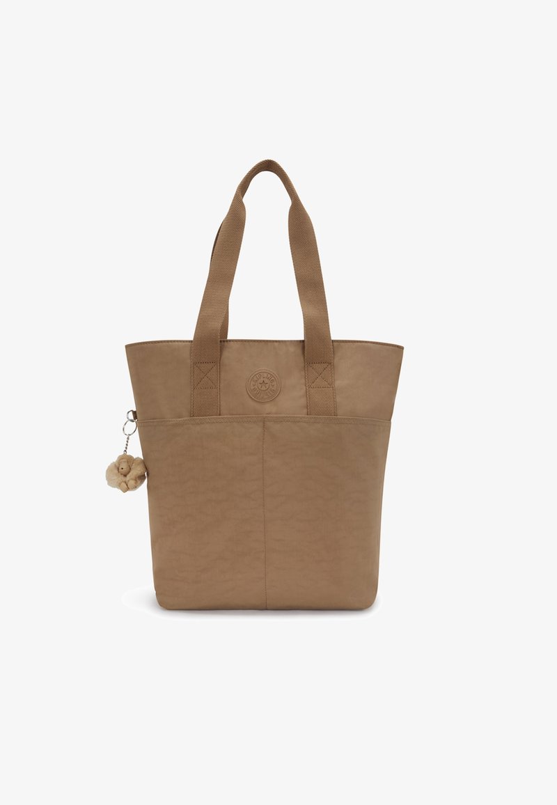 Beige tote bag with two sturdy handles, textured finish, front logo detail, and a decorative charm attached to the side.