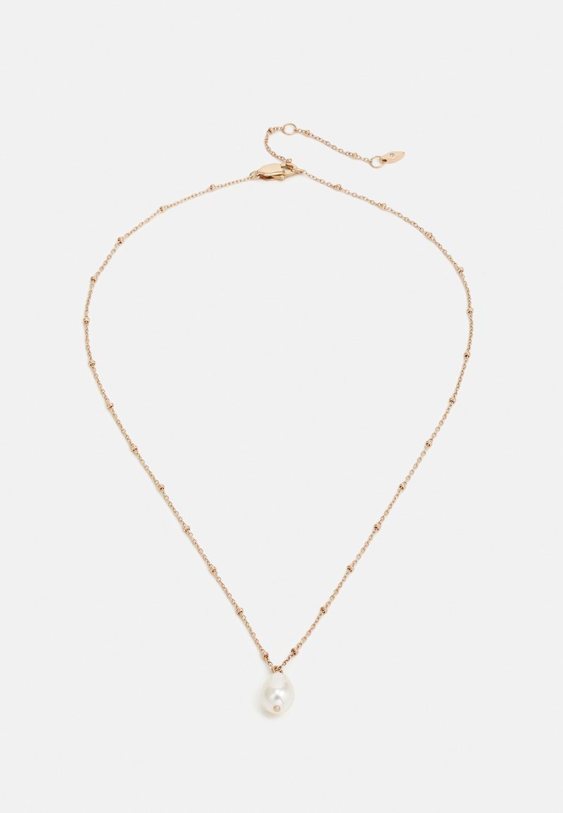 Collier chaîne en or avec petits détails de perles et un pendentif unique en grosse perle blanche sur fond blanc.