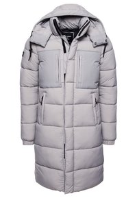 Abrigo largo acolchado de color gris claro con capucha, que presenta un cierre frontal con cremallera, textura acolchada y dos bolsillos delanteros con detalles en contraste.