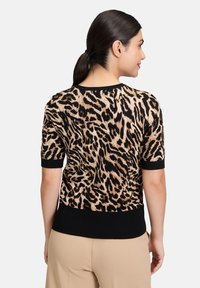 Sweter z krótkim rękawem w leopardzi wzór w odcieniach brązu i czerni. Żebrowany dekolt i dolny brzeg. Miękka, teksturowana tkanina o dopasowanym kroju.