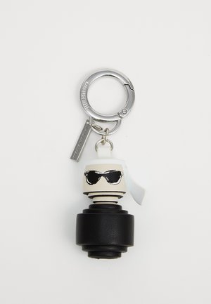 Keychain featuring a black textured base, white and black stylized head with sunglasses, and a silver metal loop and tag.