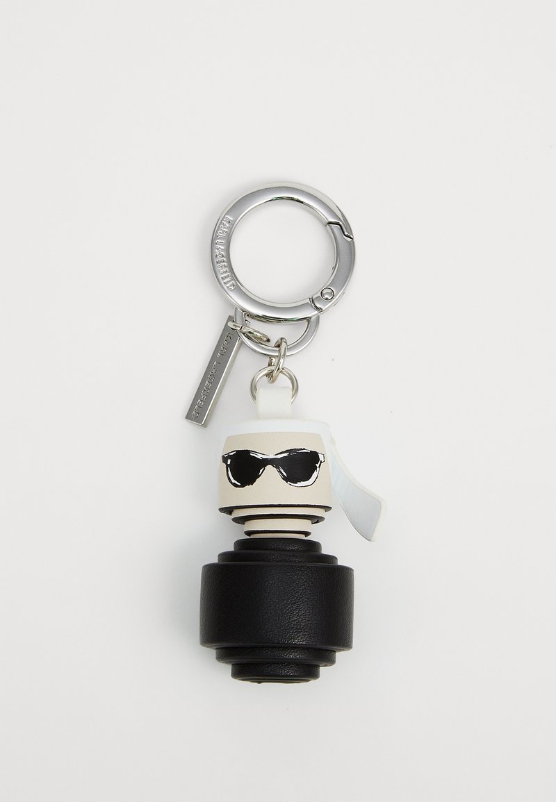 Keychain featuring a black textured base, white and black stylized head with sunglasses, and a silver metal loop and tag.