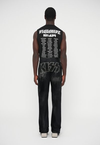 Camiseta negra sin mangas con texto blanco en la parte trasera; pantalones negros con un logo metálico y audaz de "KISS"; diseño ajustado y tela texturizada.