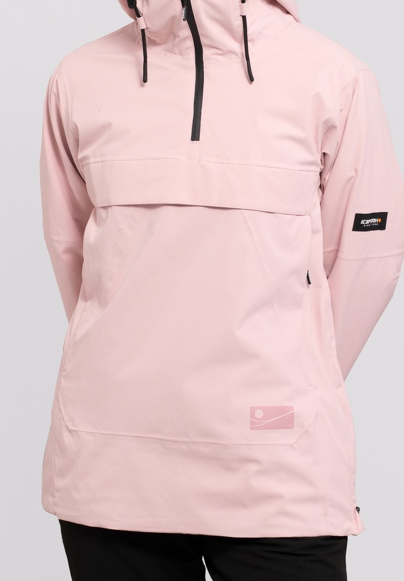 Giacca anorak rosa chiaro con tasca frontale, cerniera nera, cappuccio regolabile e patch con logo sulla manica. Texture liscia.