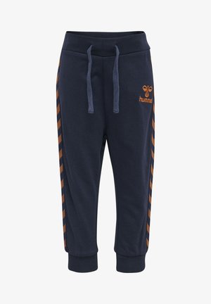 Navyblå sweatpants i bomull, med elastisk midja med dragsko och orangea chevronränder längs sidorna.