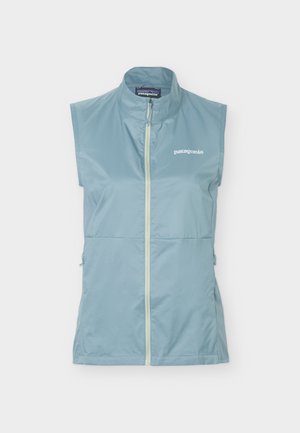 Vestă fără mâneci, albastru deschis, cu fermoar și guler în picioare, cu logo-ul Patagonia pe pieptul stâng.