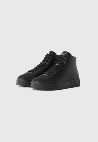 Schwarze High-Top-Sneaker aus strukturiertem Synthetikmaterial, mit einer dicken, strukturierten Sohle und flachen Schnürsenkeln, minimaler Markenkennzeichnung auf der Zunge.