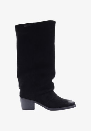Czarne zamszowe botki do kolan z luźnym krojem, okrągłym noskiem i grubym obcasem. Posiadają gładką fakturę i markową metkę na górze.