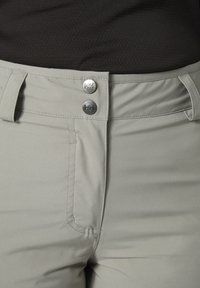 Pantalones gris claro con un acabado suave y texturizado. Presenta dos cierres de botón plateado y un diseño de bolsillo tradicional.